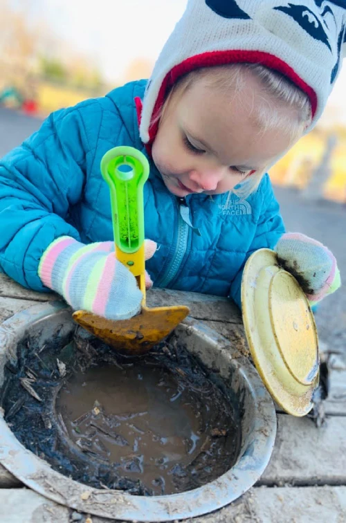 young girl playing with mud